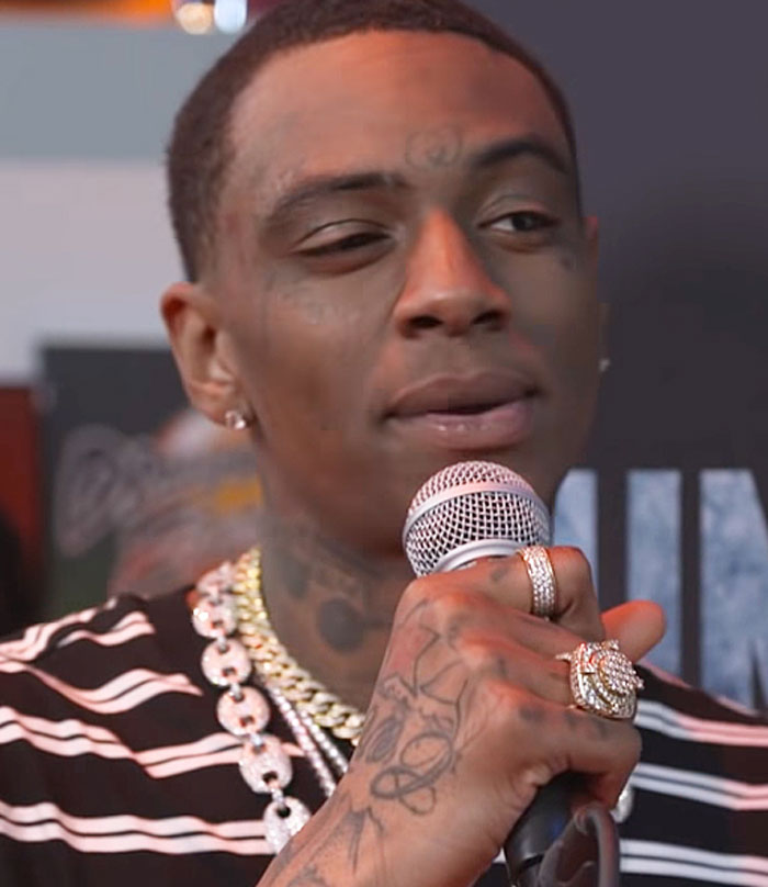 Man with tattoos and jewelry holding a microphone, speaking about the worst concert experience shared by people.