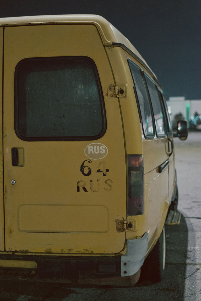 Yellow rusty van parked outdoors at night, creating a creepy atmosphere related to home alone experiences.