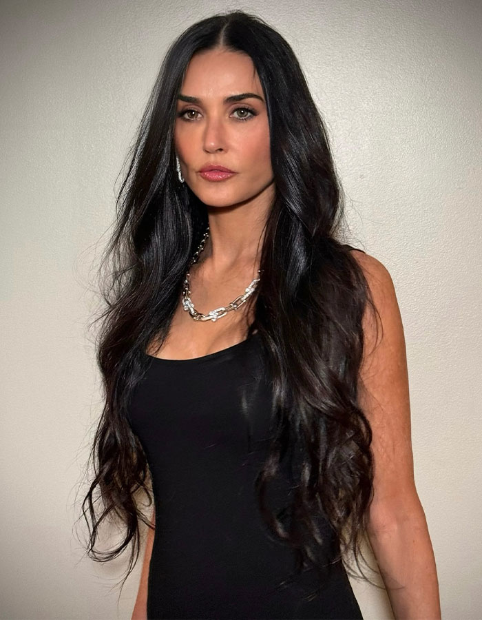 Celebrity woman with long dark hair in a black dress and silver necklace sharing raw and unfiltered confessions in memoirs.