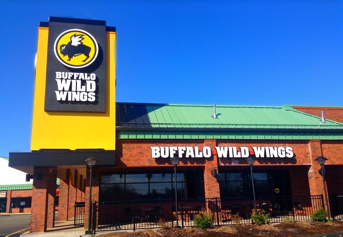 Buffalo Wild Wings restaurant exterior under clear blue sky featuring bold restaurant signage and logo.