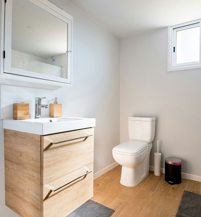Modern bathroom with wooden vanity and white toilet illustrating unexpected things men didn’t know about women.