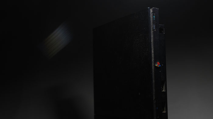 Black gaming console in low light, evoking a creepy atmosphere related to creepy things that happened while home alone.