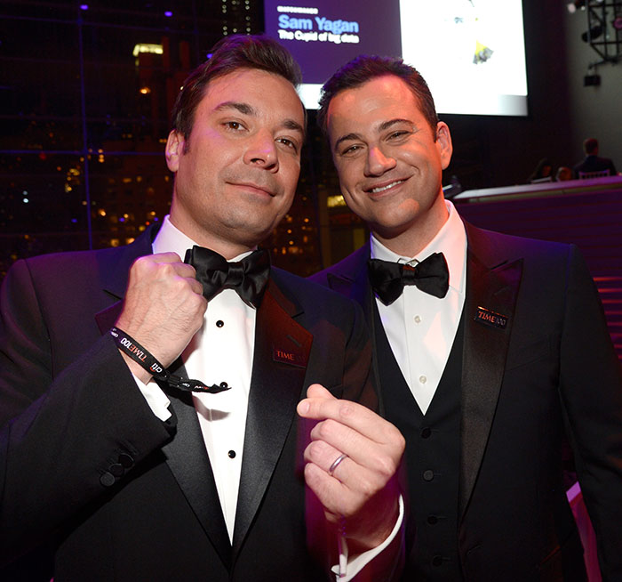 Jimmy Fallon and Jimmy Kimmel smiling in tuxedos at an event, relating to show suspension and TV host discussions.