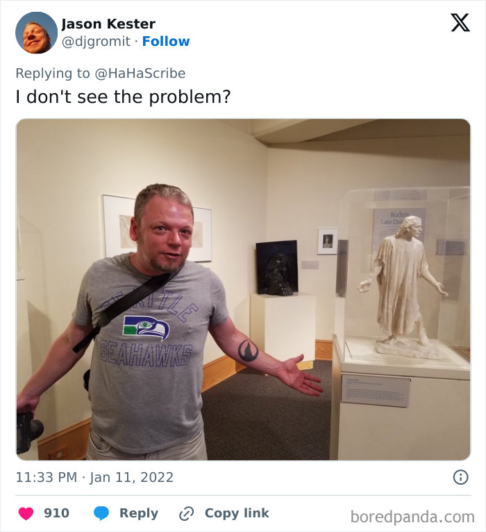 Man in Seattle Seahawks shirt posing next to a statue, illustrating life imitating art in a museum setting.
