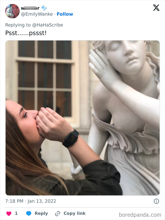 Person mimics a statue by whispering to its ear, showcasing life imitating art in a creative outdoor setting.