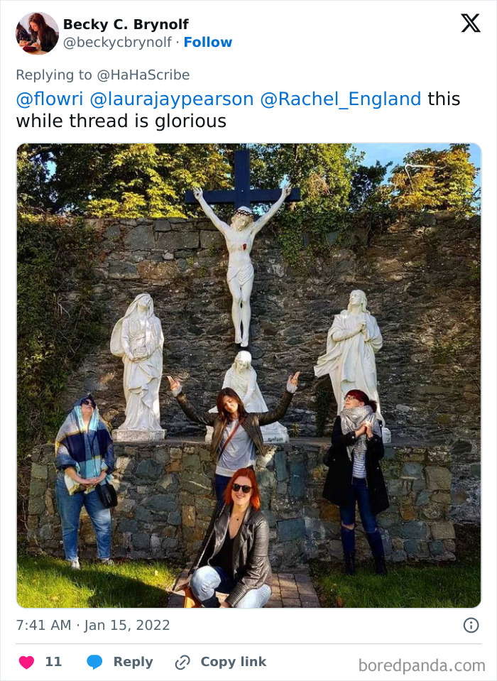 Four people posing creatively in front of statues imitating iconic art in an outdoor stone garden setting.