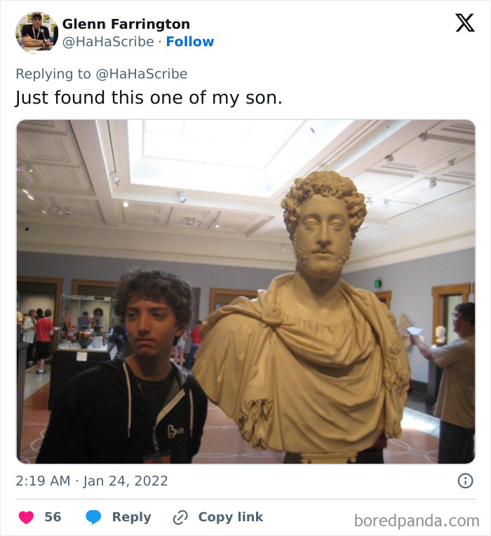Young man standing next to a classical bust in a museum, showcasing life imitating art with similar hairstyles and expressions.
