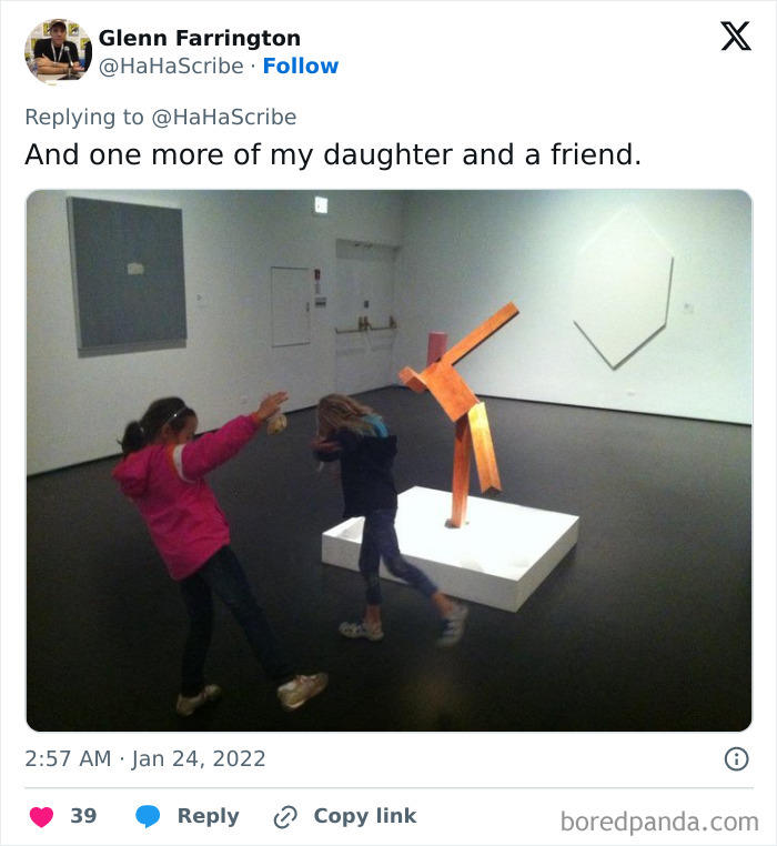 Two girls in an art gallery perfectly mimicking the pose of a wooden sculpture, showcasing life imitating art.