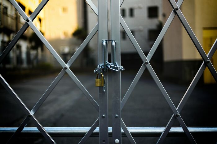 Locked metal gate with chain and padlock blocking entrance, symbolizing chaotic stories shared by food delivery drivers.