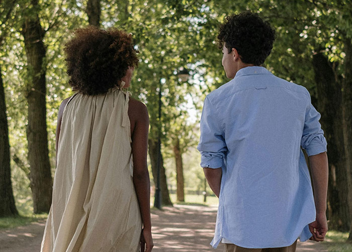 Two people walking on a tree-lined path, illustrating incredible coincidences that sound fake but are true.