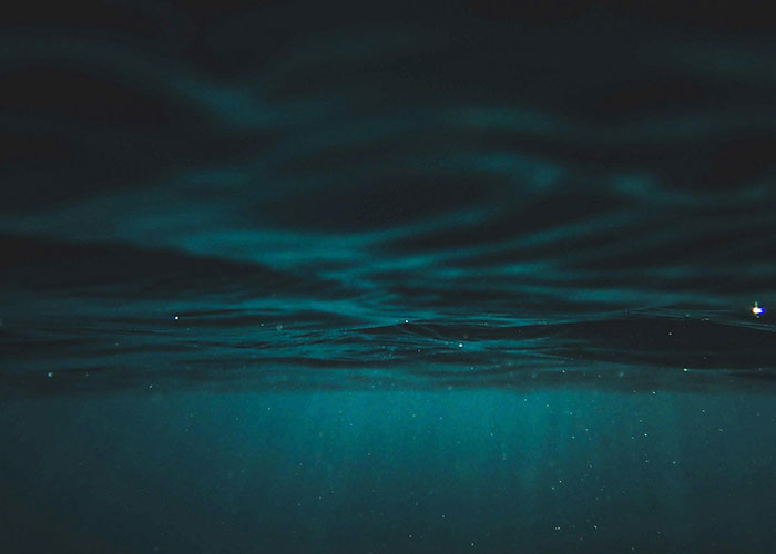 Dark underwater scene with faint light rays, evoking a mysterious atmosphere related to terrifying true stories.