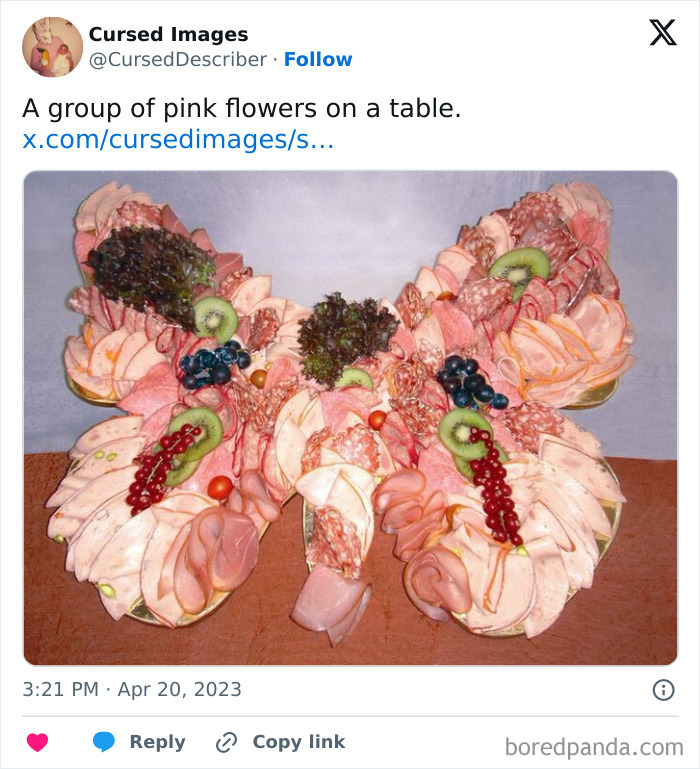Meat and fruit arranged in a disturbing and cursed pattern resembling butterfly wings on a table.
