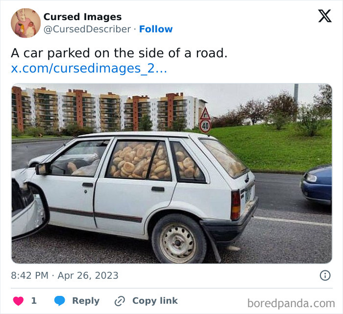 A white car filled entirely with bread rolls parked on a road near apartment buildings and green grass.