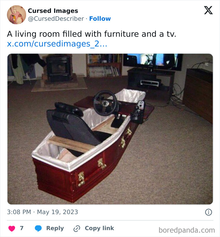 A disturbing picture of a coffin repurposed as a racing simulator seat with gaming controls in a living room.
