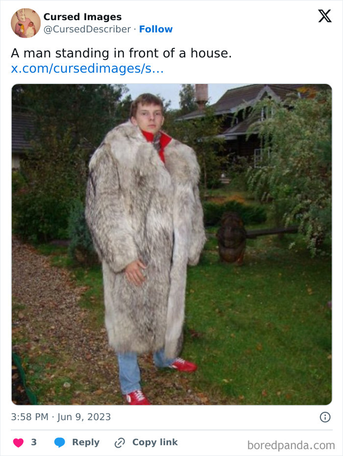 Young man wearing oversized fur coat standing on grass in front of a house, disturbing pictures concept.