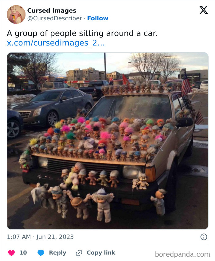 Car covered in disturbing troll dolls and figurines, creating a creepy and cursed visual effect in a parking lot.