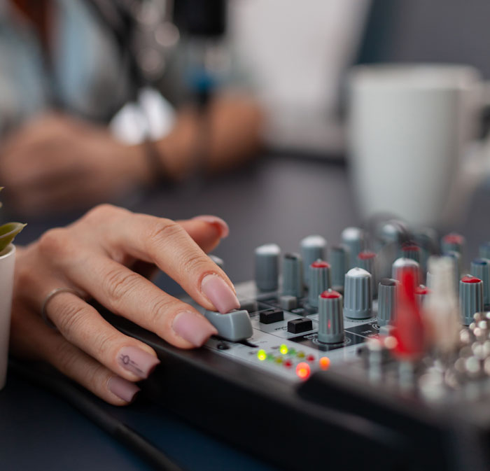 Close-up of a hand adjusting knobs on an audio mixing console illustrating brilliant loopholes exploited with zero regrets.
