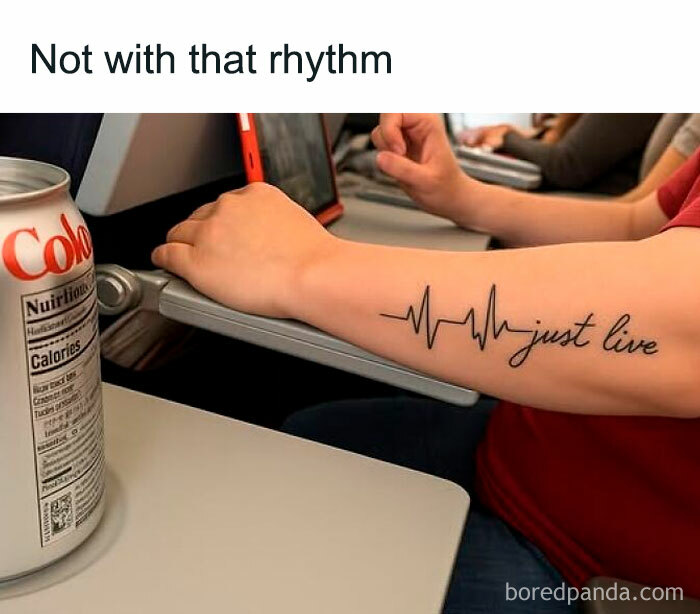 Arm tattoo of a heart rhythm with the words just live, hands typing on a laptop, and a soda can on the table, EMT paramedic humor.