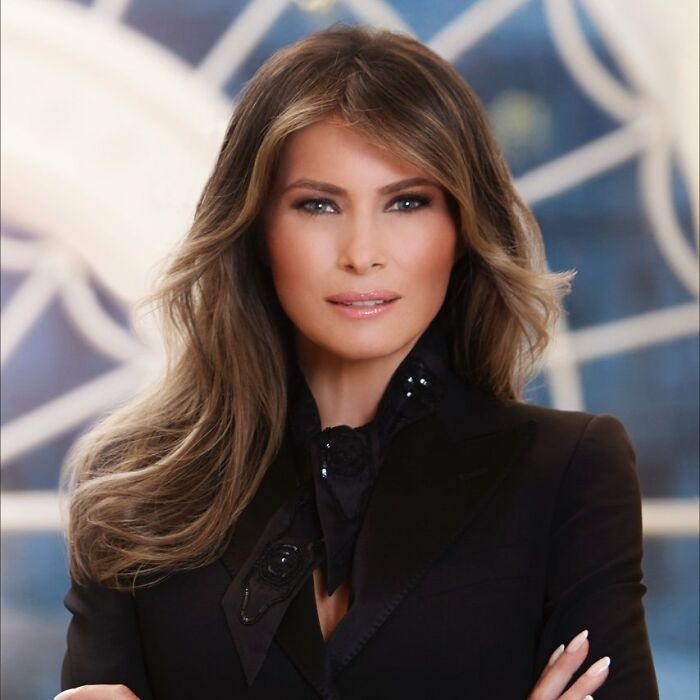 Melania Trump in a black outfit with styled hair posing confidently, focus on body language expert analysis. Melania Trump in a black outfit with styled hair posing confidently, focus on body language expert analysis.