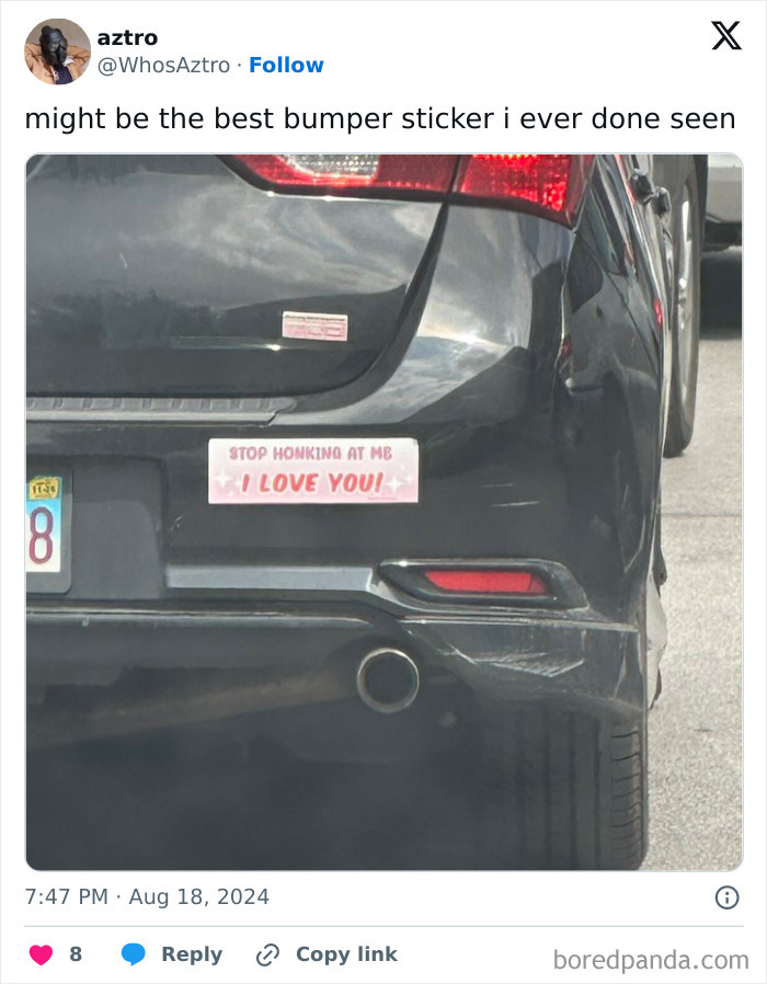 A black car with a funny bumper sticker reading stop honking at me I love you spotted on the road.