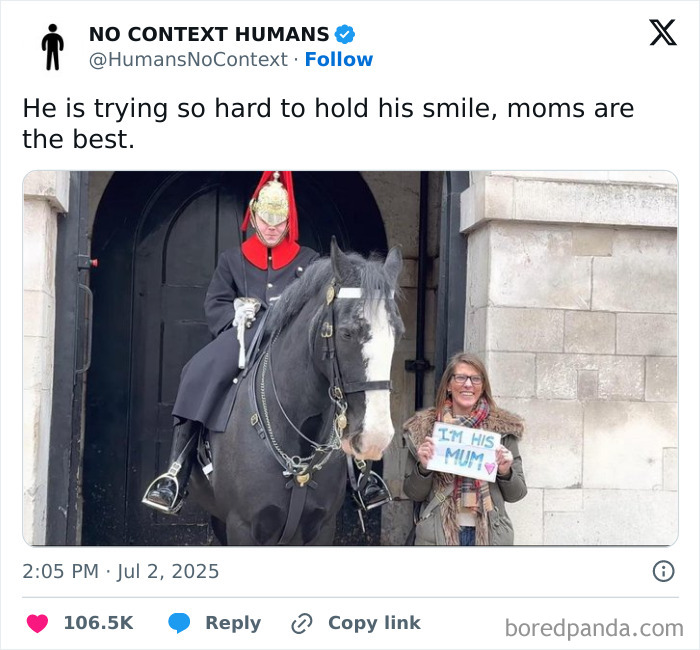 Mom holding a sign next to a mounted guard smiling softly, showing wholesome mom moments and happiness.