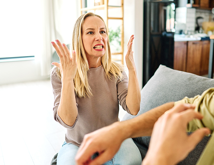 Angry woman angrily gesturing during a heated argument with man about refusing to check restaurant menu.