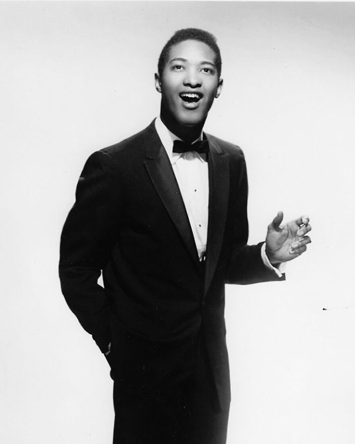 Black and white photo of a male celebrity in a tuxedo, representing male celebrities who were slain by women.