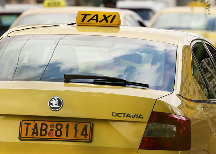 Yellow taxi car with license plate TAB 8114, showcasing a rare coincidence on a busy street scene.