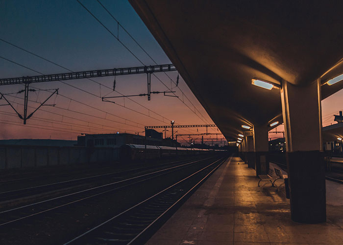 Dimly lit empty train station platform at dusk, evoking eerie and terrifying true stories atmosphere.
