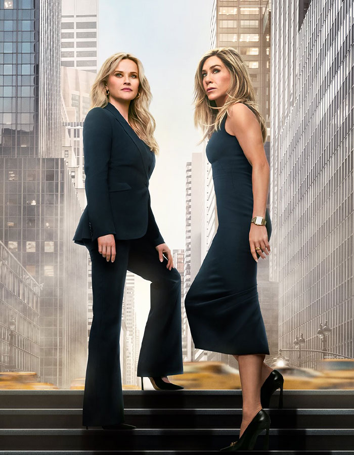 Jennifer Aniston and Reese Witherspoon standing in cityscape, highlighting friendship and surprise discovery moment.