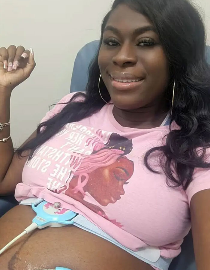 Pregnant woman smiling while undergoing fetal monitoring, highlighting doctors' concerns over rise in giant baby births. Pregnant woman smiling while undergoing fetal monitoring, highlighting doctors' concerns over rise in giant baby births.