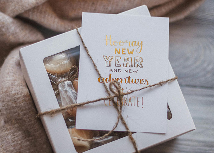 Gift box and card wrapped with string showing common purchases people have ditched due to ridiculous price tags.