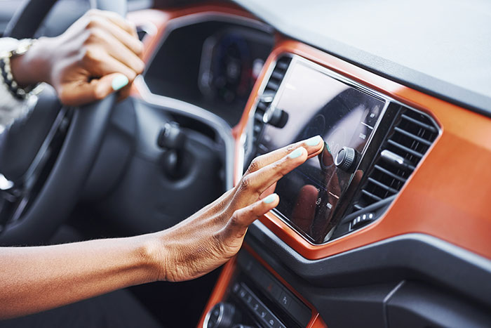 Person interacting with a car touchscreen display illustrating the inclusion of AI into everything trend in technology.