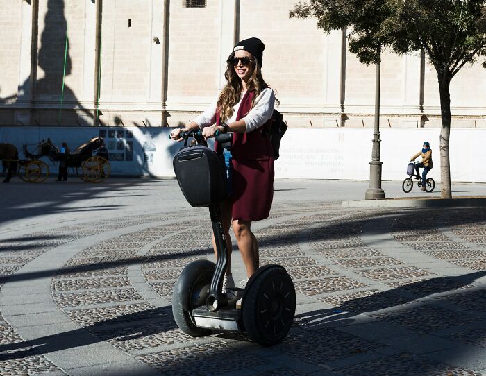 Woman smiling riding a Segway in an urban area showcasing the next big thing with a device that totally flopped.