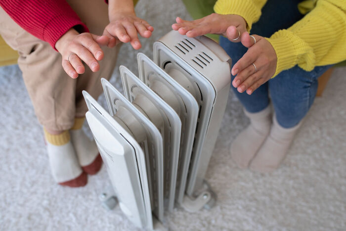 Two people warming hands by a heater, symbolizing care in rare disease patient encounters by doctors.