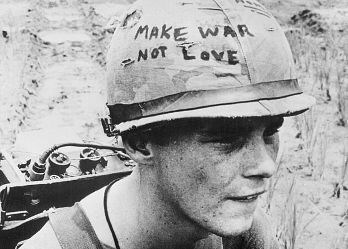 Soldier wearing a helmet with make war not love message, symbolizing the damage of historical events to society.