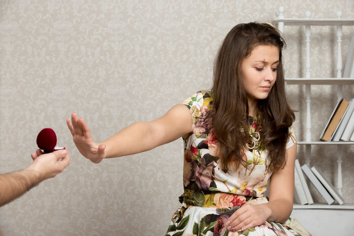 Woman in floral dress refusing a marriage proposal, illustrating absurd dealbreakers that ruined relationships.