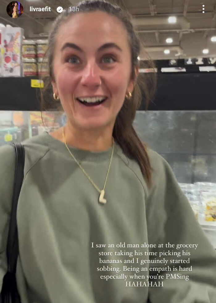 A woman in a green sweatshirt smiling at a grocery store, illustrating unhinged fitness influencers taking babies to the gym.