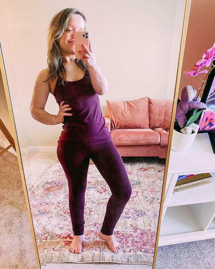 31YO woman with dwarfism wearing purple outfit taking a mirror selfie showing her height surgery transformation.