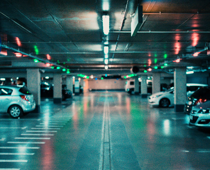 Underground parking lot with cars and colorful LED lights illustrating brilliant loopholes exploited by people.