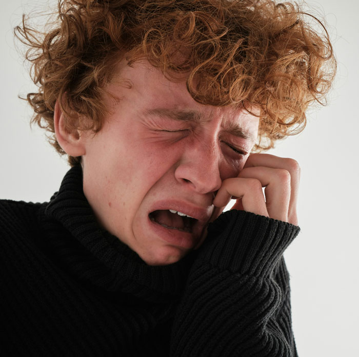 Young man crying and distressed after parents expect son to give up his life to care for autistic brother