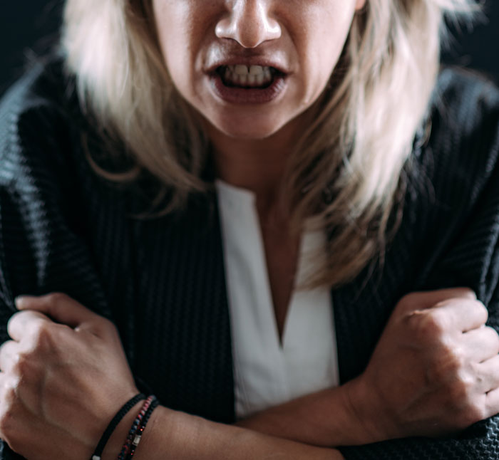 Angry woman crossing arms, expressing frustration, illustrating conflict in family caregiving for autistic brother.