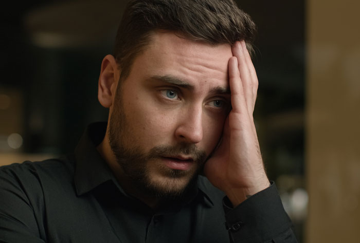 Stressed man holding his head, reflecting on a difficult lesson after giving his wife another chance in their relationship.