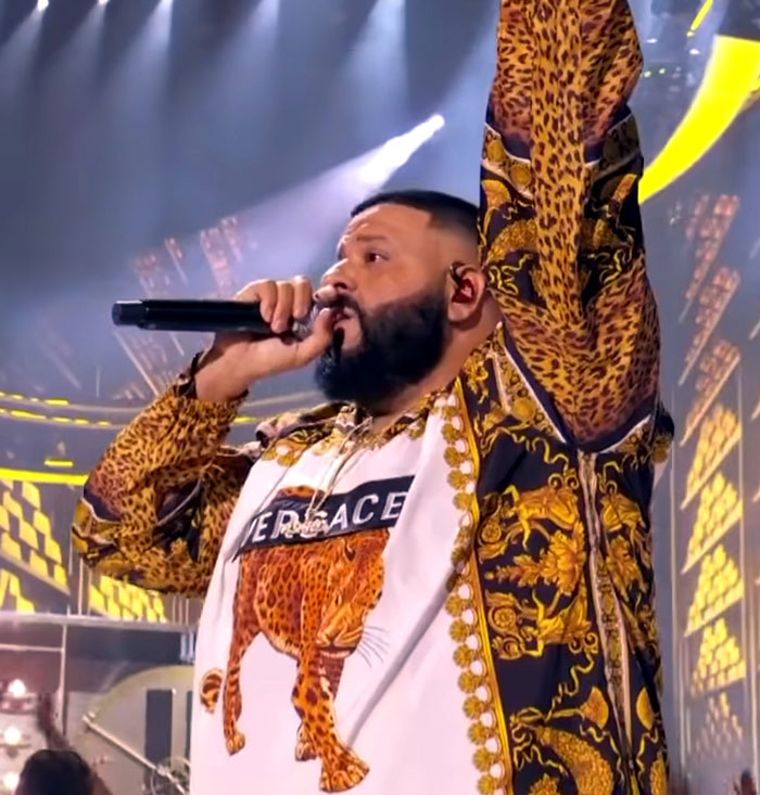 Performer in leopard print outfit singing on stage with microphone during a concert about worst concert regrets.