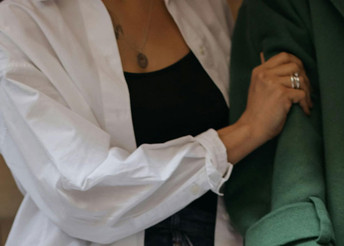 Woman grabbing man's arm uncomfortably, illustrating creepy things women do that cross the line according to men.