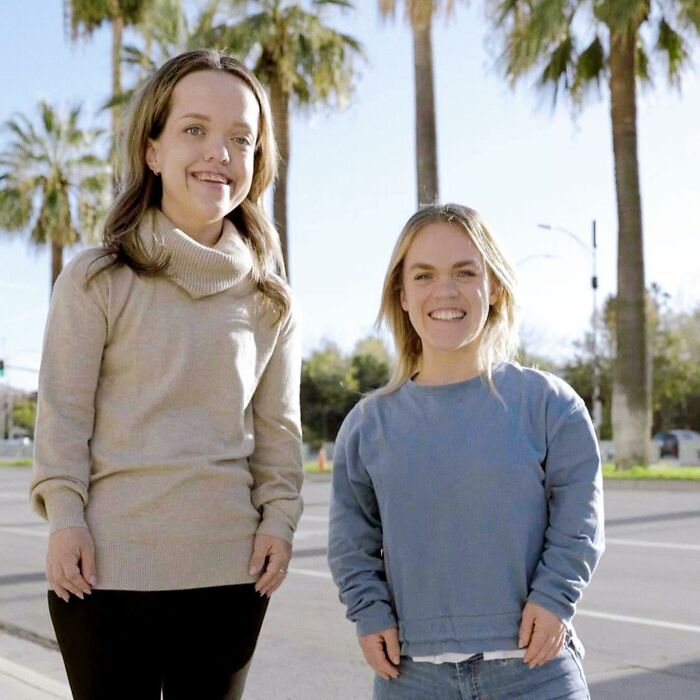 31YO woman with dwarfism smiling outdoors with friend, showcasing transformation after height surgery as a teen.