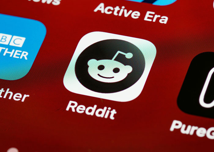 Reddit app icon on a smartphone screen, illustrating a platform where incredible coincidences are often shared and discussed.