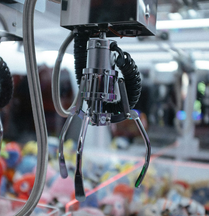 Claw machine grabbing toys in arcade with shiny metal grip showcasing a clever loophole exploit concept.