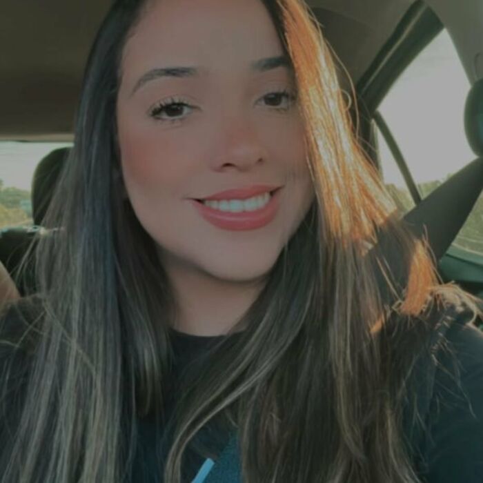 Young woman smiling in a car seatbelt, related to plastic surgeon arrested after mom&rsquo;s butt lift procedure gone wrong.