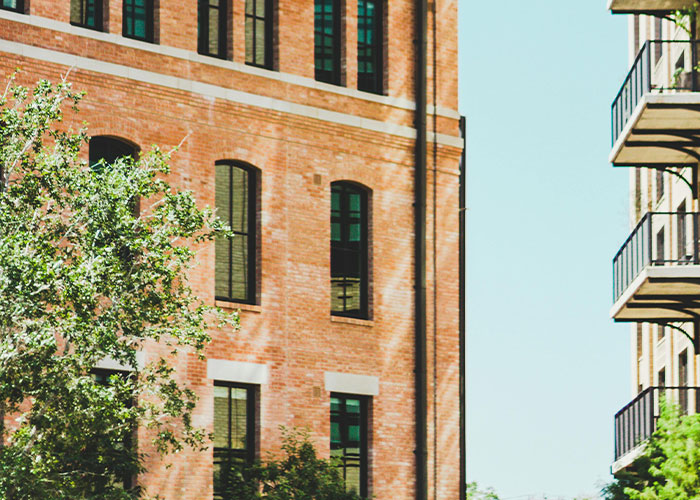 Brick apartment building exterior with balconies and trees, showcasing hidden gems people discovered after moving into new homes